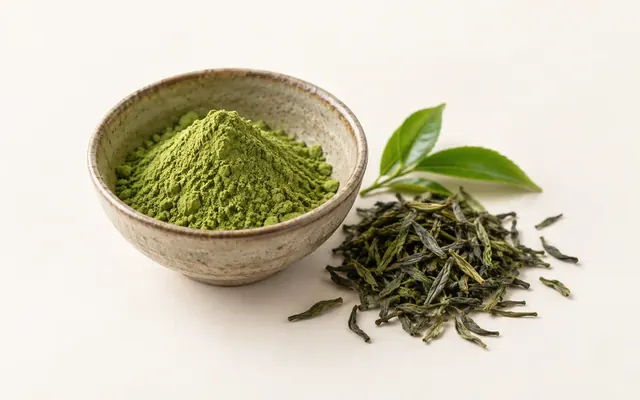 一碗鮮綠色抹茶粉,旁邊一把綠茶葉