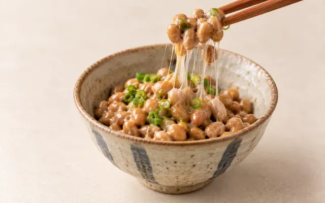 一小碗日式納豆,筷子拉起細長黏絲