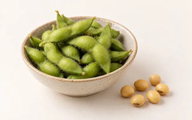 一小碗帶莢毛豆,旁邊幾顆乾黃豆